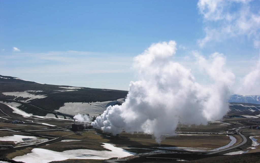 A drilling rig operating at a geothermal site with steam rising