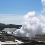 A drilling rig operating at a geothermal site with steam rising