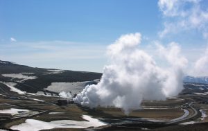 A drilling rig operating at a geothermal site with steam rising