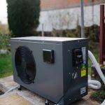 An air-source heat pump unit installed beside a house