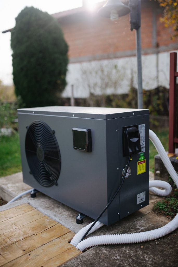 An air-source heat pump unit installed beside a house
